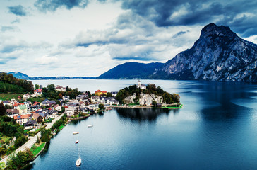 Fototapeta premium Aerial view of Austrian lake with beautuful mountain landscape and caslte on a hill