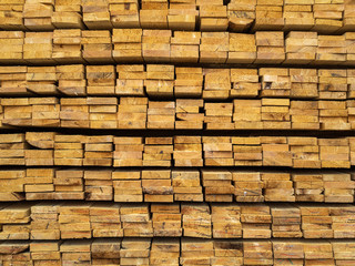 Lots of planks stacked on top of each other in the warehouse. Lumber for further use in construction