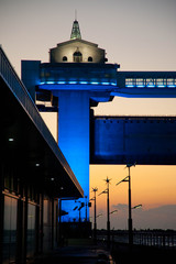 青にライトアップされた沼津港の施設よ夕焼け
