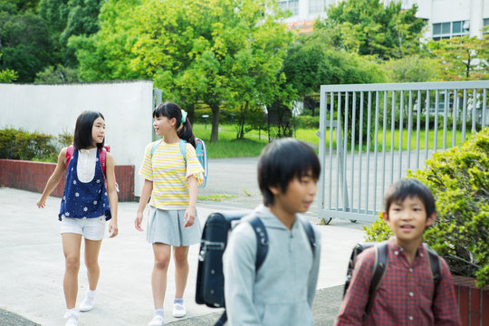 校門を出る小学生男女