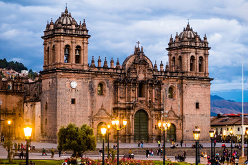 Cathedral of Cusco, Peru in the light of lanterns with mountains at the background