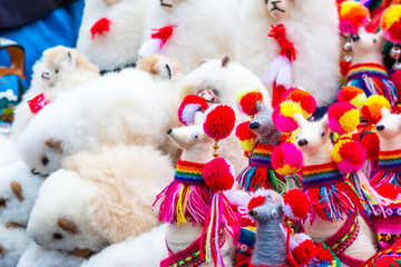 Fluffy white toy lama on the street souvenir shop in Peru