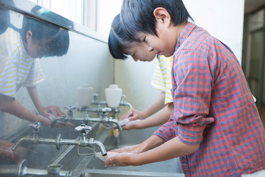 水道場で手を洗う小学生男女