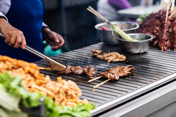 Chef cooking meat on the street