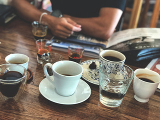 coffee cupping , Espresso cup on the wooden table with a man and magazine background.