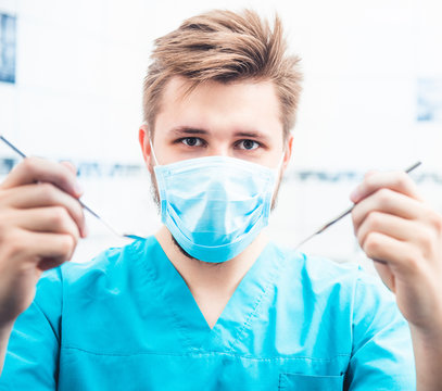 Dentist with mask and uniform holding tools