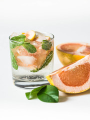 Cocktail or lemonade with mint and grapefruit in glass. Fruit lemonade. White background. Healthy citrus summer drink.