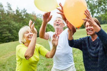 Fröhliche Senioren spielen mit Luftballons