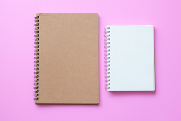 Fototapeta premium brown cover notebook with open blank paper notebook on pink background. 