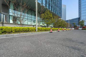 Naklejka premium empty asphalt road near glass office building.