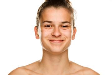 Portrait of young smiling woman without makeup on white background