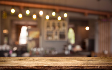 image of wooden table in front of abstract blurred background of resturant lights