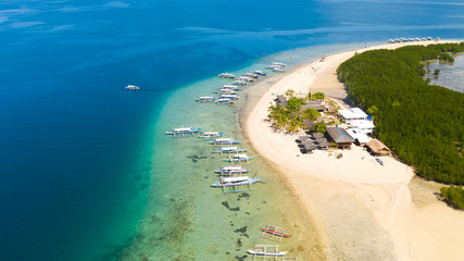 Starfish Island, Puerto Princesa, Palawan. Lots of boats on the beach, tourist route. Island hopping Tour at Honda Bay, Palawan. An island of white sand with mangroves.