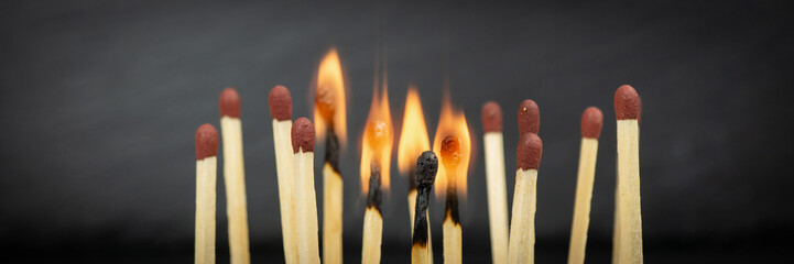 A group of matches, some of which are burning, banner