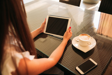 Mock up of woman sitting in cafe and use tablet and phone