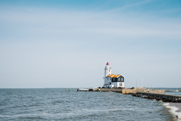 Fototapeta premium Panoramic view of lighthouse on coast of Marken, Netherlands