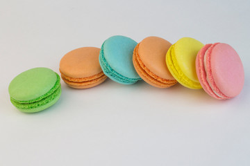 Macaroon sweet biscuits, French pastries of different colors on a white background, macaroni scattered on a white table