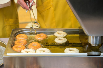 Street food. The process of baking in hot butter donuts.