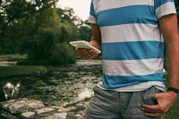 Trendy man using cellphone outdoors.