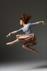 the modern dancer jumping on a gray background