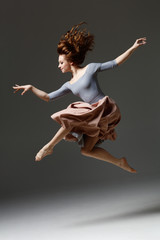 the modern dancer jumping on a gray background