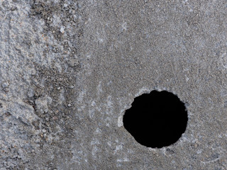 Sol en parpaing gris avec un trou