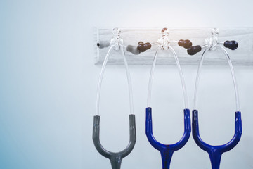 Stethoscope hangs from a coat rack hook in a hospital room.(blue tone concept)
