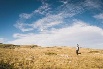 Beautiful summer sunny mountain landscape with a clear blue sky with clouds background. Crimean mountains. young man is running small paraglider. Learning paragliding. Launch a paraglider