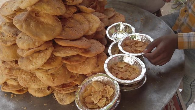 Close-up of Mathri Aloo, classic savory Indian snack or crackers. A flaky biscuit made from flour, water, and cumin seeds served with potato masala curry. slow motion Handheld stabilized gimbal 4k