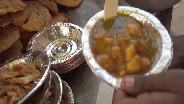 Close-up of Mathri Aloo, classic savory Indian snack or crackers. A flaky biscuit made from flour, water, and cumin seeds served with potato masala curry. slow motion Handheld stabilized gimbal 4k