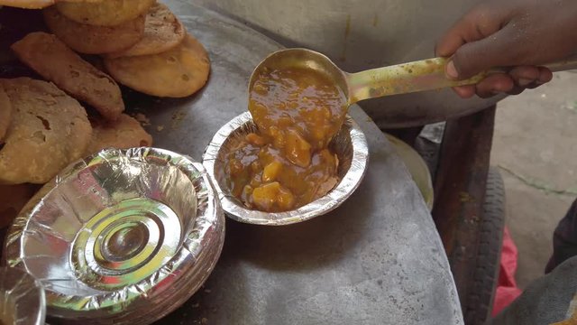 Close-up of Mathri Aloo, classic savory Indian snack or crackers. A flaky biscuit made from flour, water, and cumin seeds served with potato masala curry. slow motion Handheld stabilized gimbal 4k