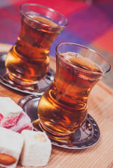 Traditional turkish tea in the glass with lokum delights 