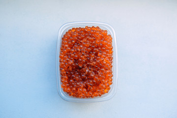 Salmon caviar close-up. Plastic containers with red caviar isolated on white background. Sea delicacy, fresh catch.