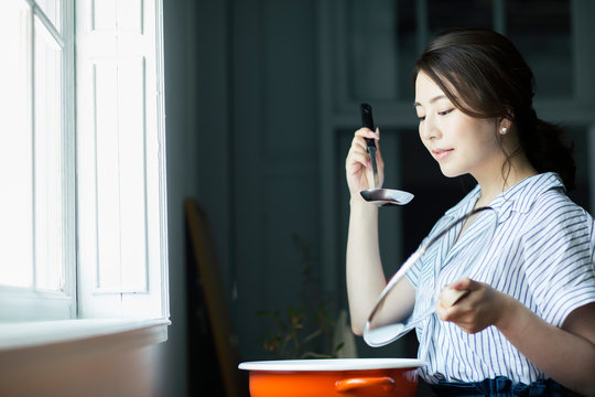 料理の味見をする20代女性