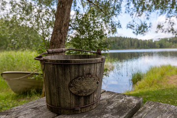 An old wooden bucket and the lake on the background, Finland