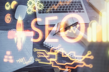 Multi exposure of woman's hands making notes with SEO icon. Concept of Search engine optimization