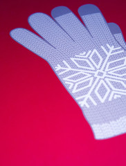 Image of grey winter glove on red background