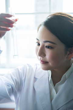 試験管の中の液体の様子を確認する20代研究員