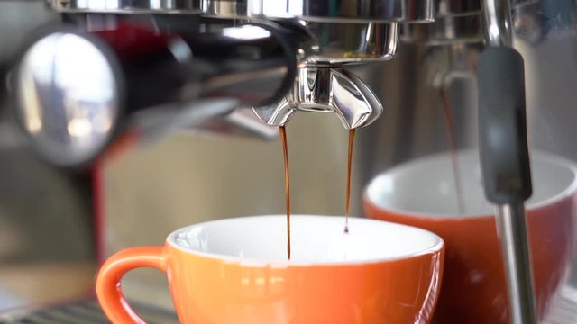 Slow motion clip of Espresso coffee being extracted from a machine
