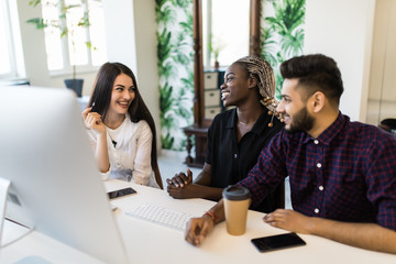 International confident team leader mentor use computer sitting together with diverse female...