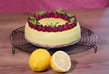 Classic New York Cheesecake with fresh raspberries and mint on plate.