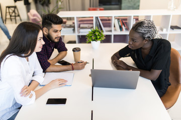 Young international professional team discussing business plan in the office