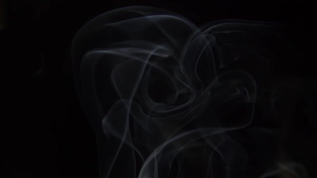 puffs of white smoke rise from the bottom up on a black background