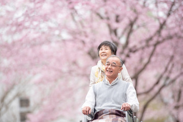 車椅子で散歩するシニア夫婦