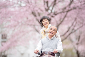 車椅子で散歩するシニア夫婦