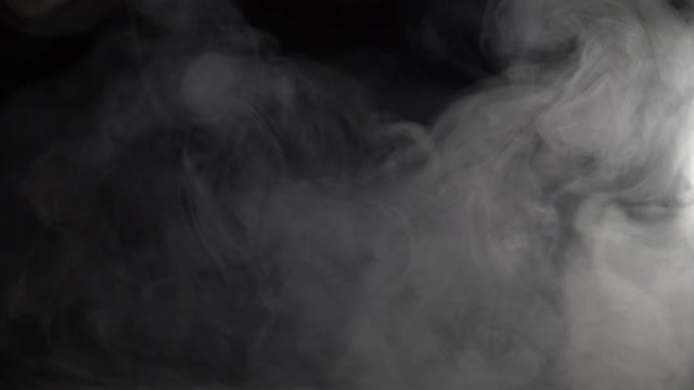 blowing white smoke on a black background