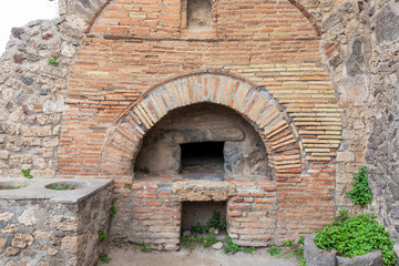 Fototapeta na wymiar Pompeii, Italy. 04-22-2019. Ruins of a bakery at antique Roman city of Pompeii, Italy.