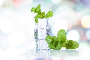 ice cubes and splashing water with mint on a colored background