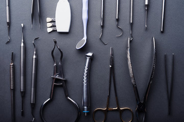 Closeup of different dental instruments composed on gray background