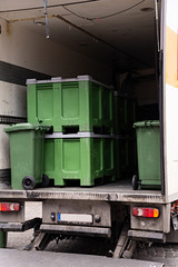 Camión cargado con cubos de basura y contenedores.